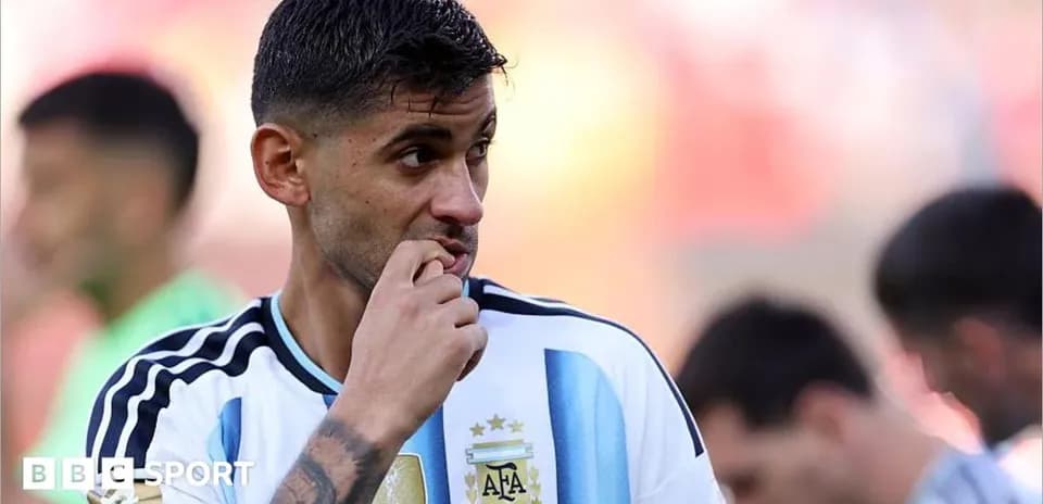 Jugador argentino con camiseta blanca y celeste pensativo