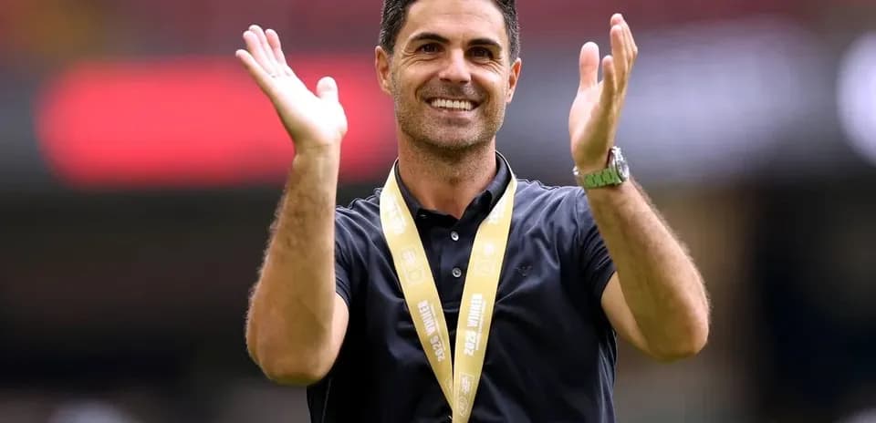 Entrenador aplaudiendo con medalla colgada al cuello