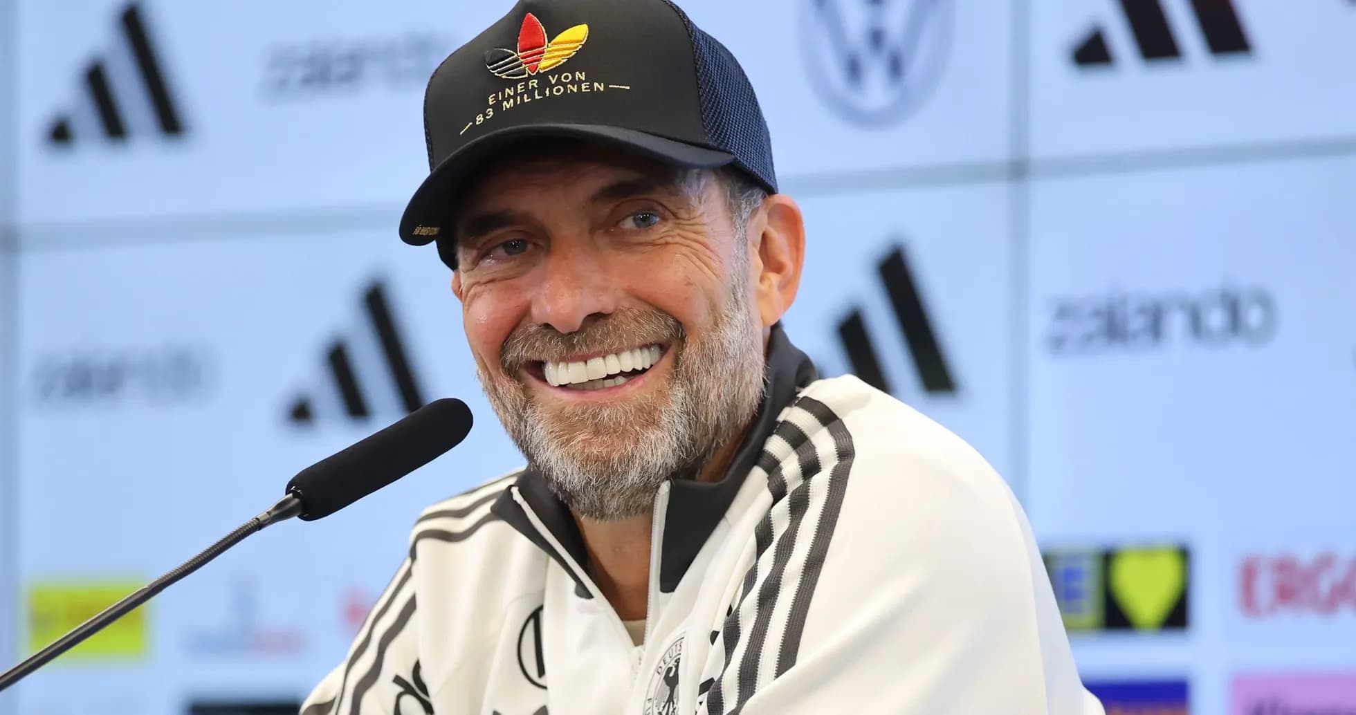 Entrenador en conferencia de prensa sonriente
