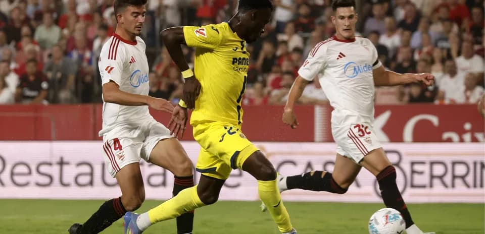 Jugador del Villarreal driblando entre defensores del Sevilla