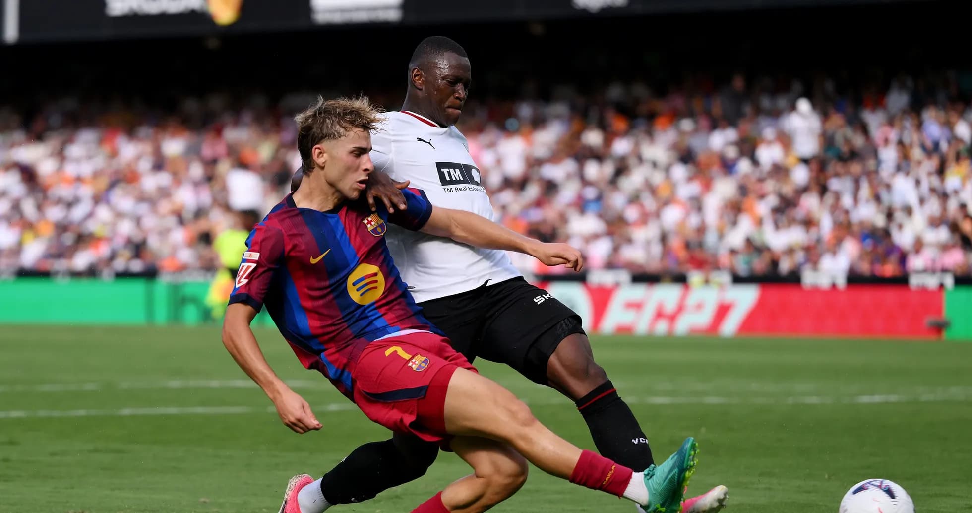 Jugador de Barcelona deslizándose tras el balón