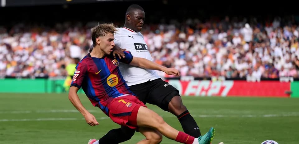 Jugador de Barcelona deslizándose tras el balón