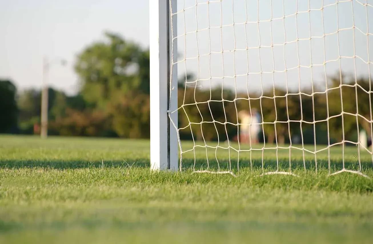 Portería de fútbol en campo verde al atardecer