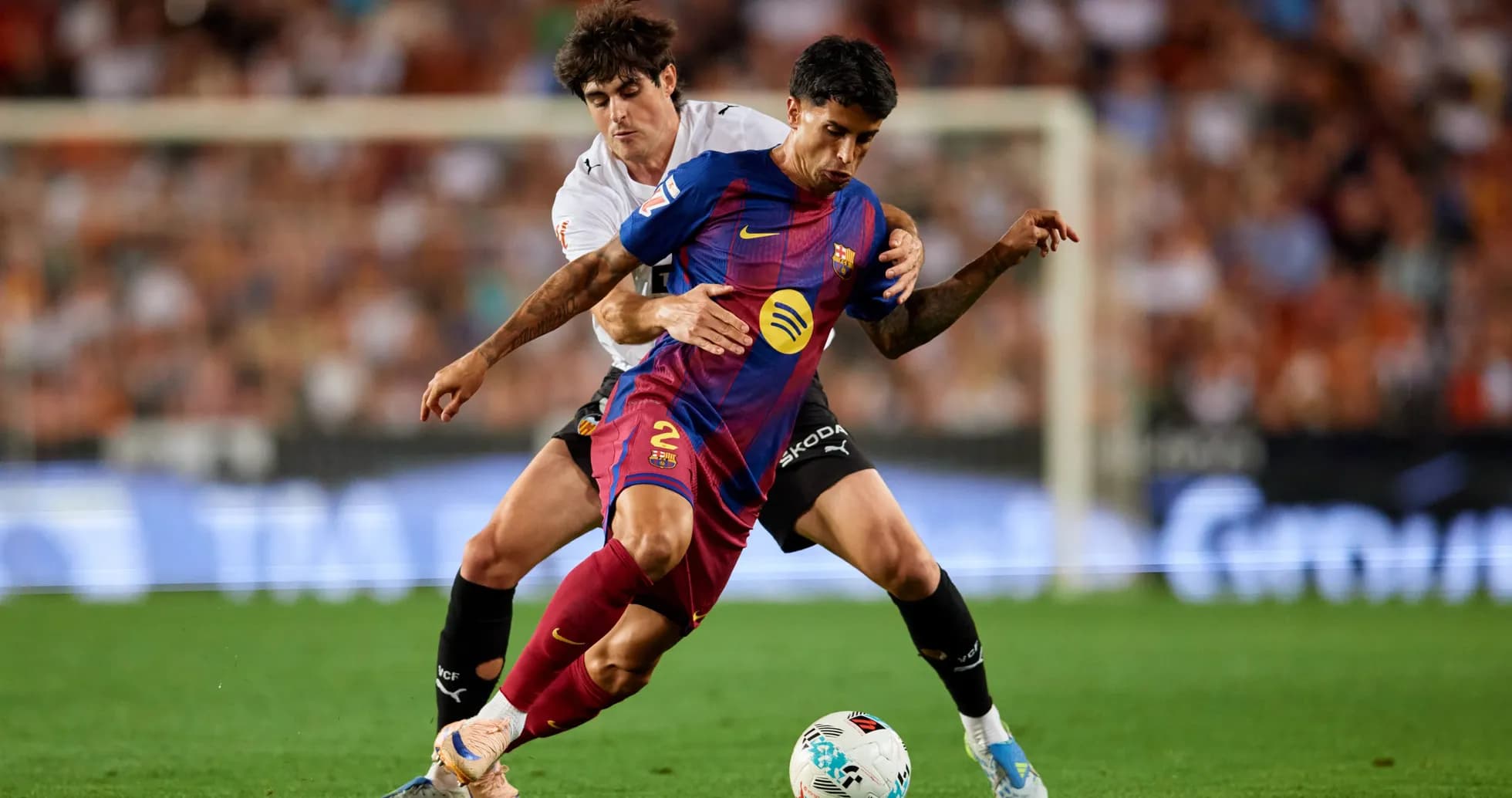 Jugadores de Barcelona y Valencia luchando por el balón