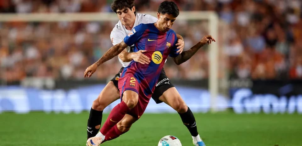 Jugadores de Barcelona y Valencia luchando por el balón