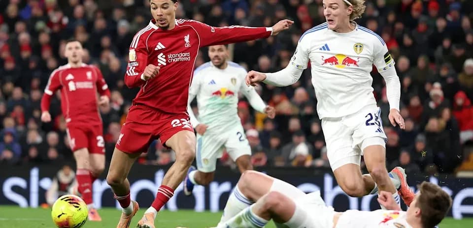 Jugador de Liverpool driblando entre oponentes de Leeds