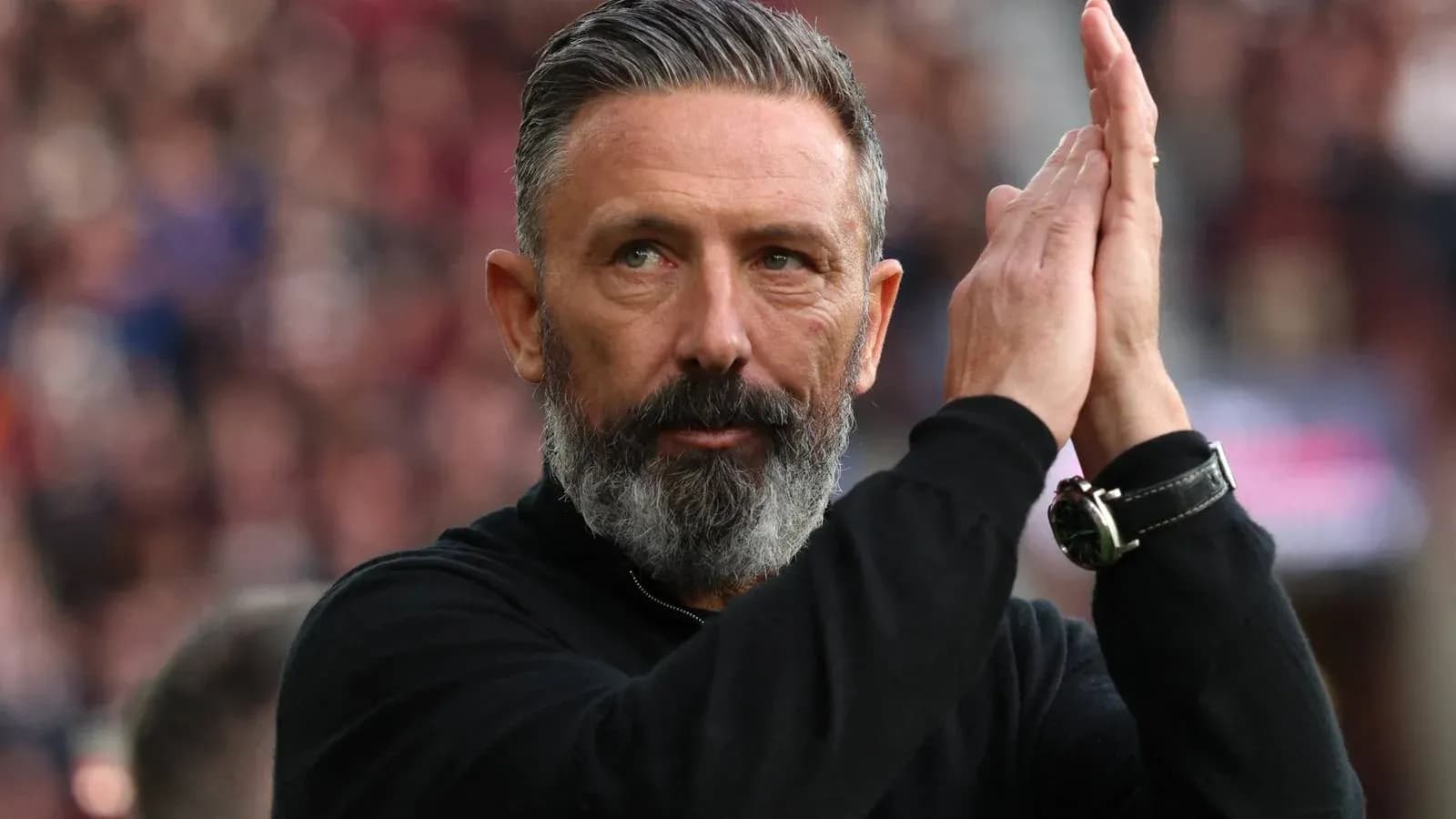 Entrenador aplaudiendo a la afición en el estadio