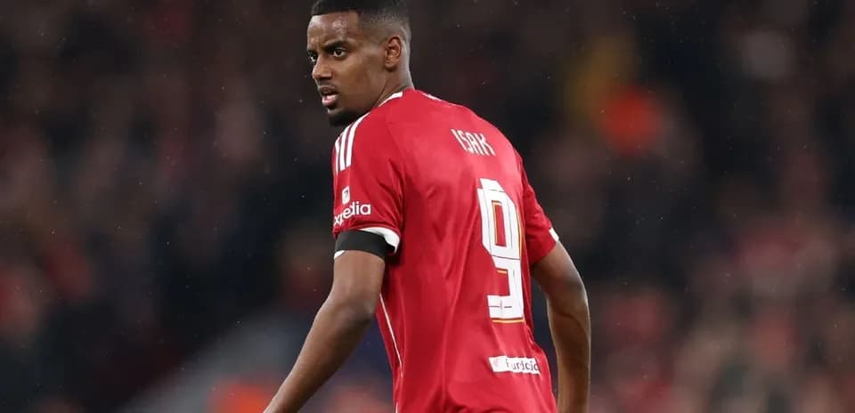 Jugador con camiseta roja mirando hacia atrás en el campo