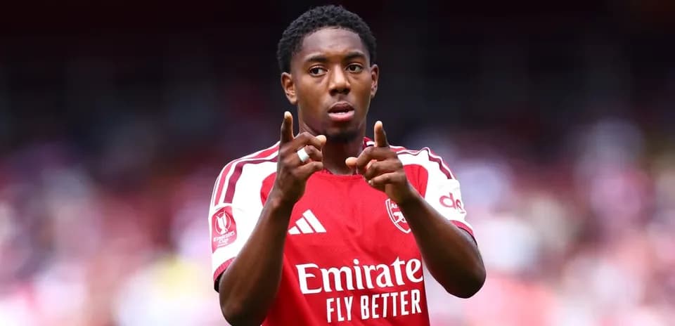 Jugador señalando durante partido con camiseta de Arsenal