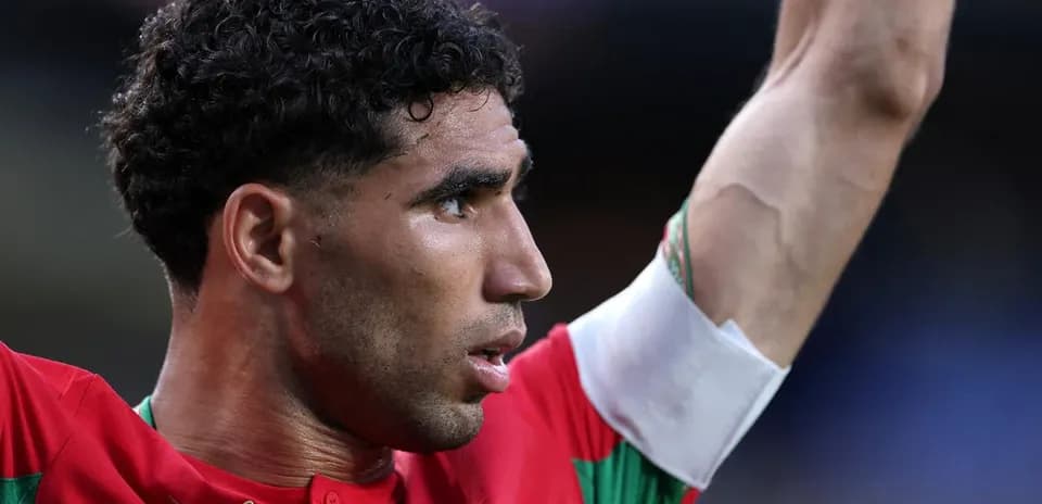 Jugador levantando el brazo en partido de fútbol