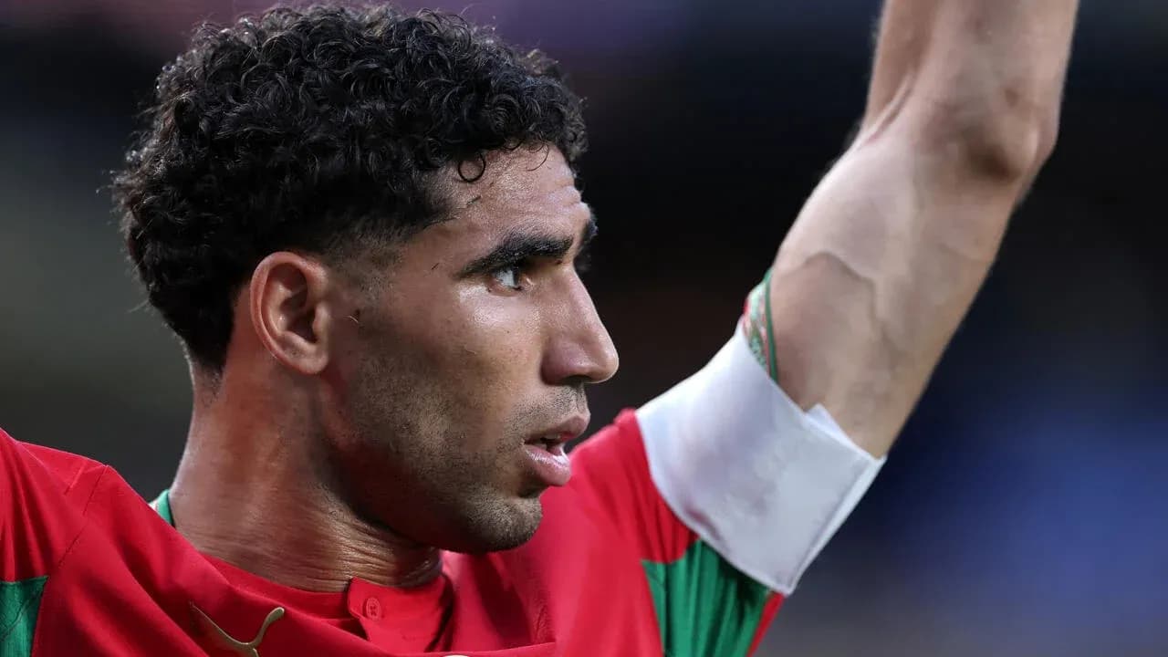 Jugador levantando el brazo en partido de fútbol