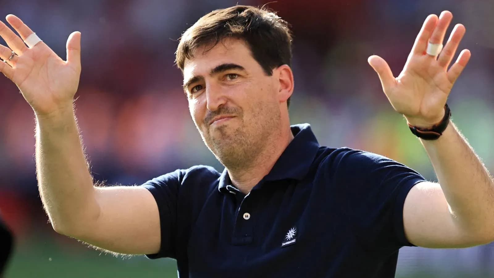 Entrenador saludando al público en el estadio
