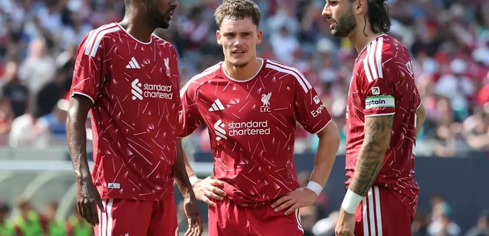 Jugadores de Liverpool conversando en el campo