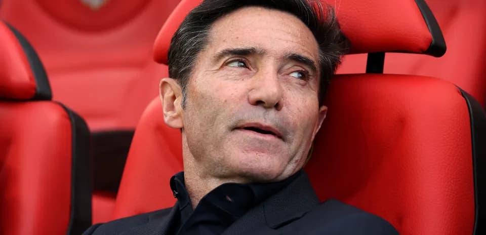 Entrenador sentado en banquillo rojo durante el partido