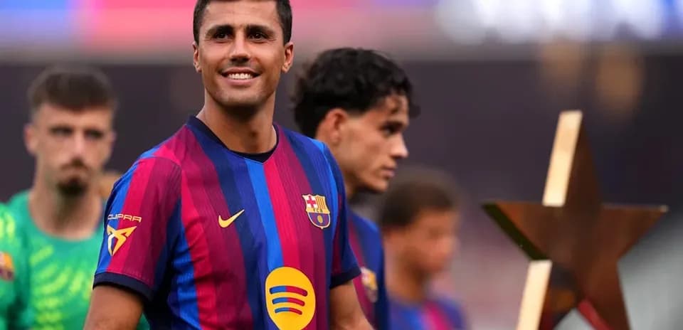 Jugador de FC Barcelona sonriente con trofeo en mano