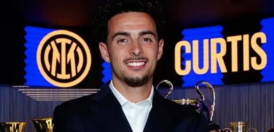 Jugador sonriente junto a trofeos de Inter