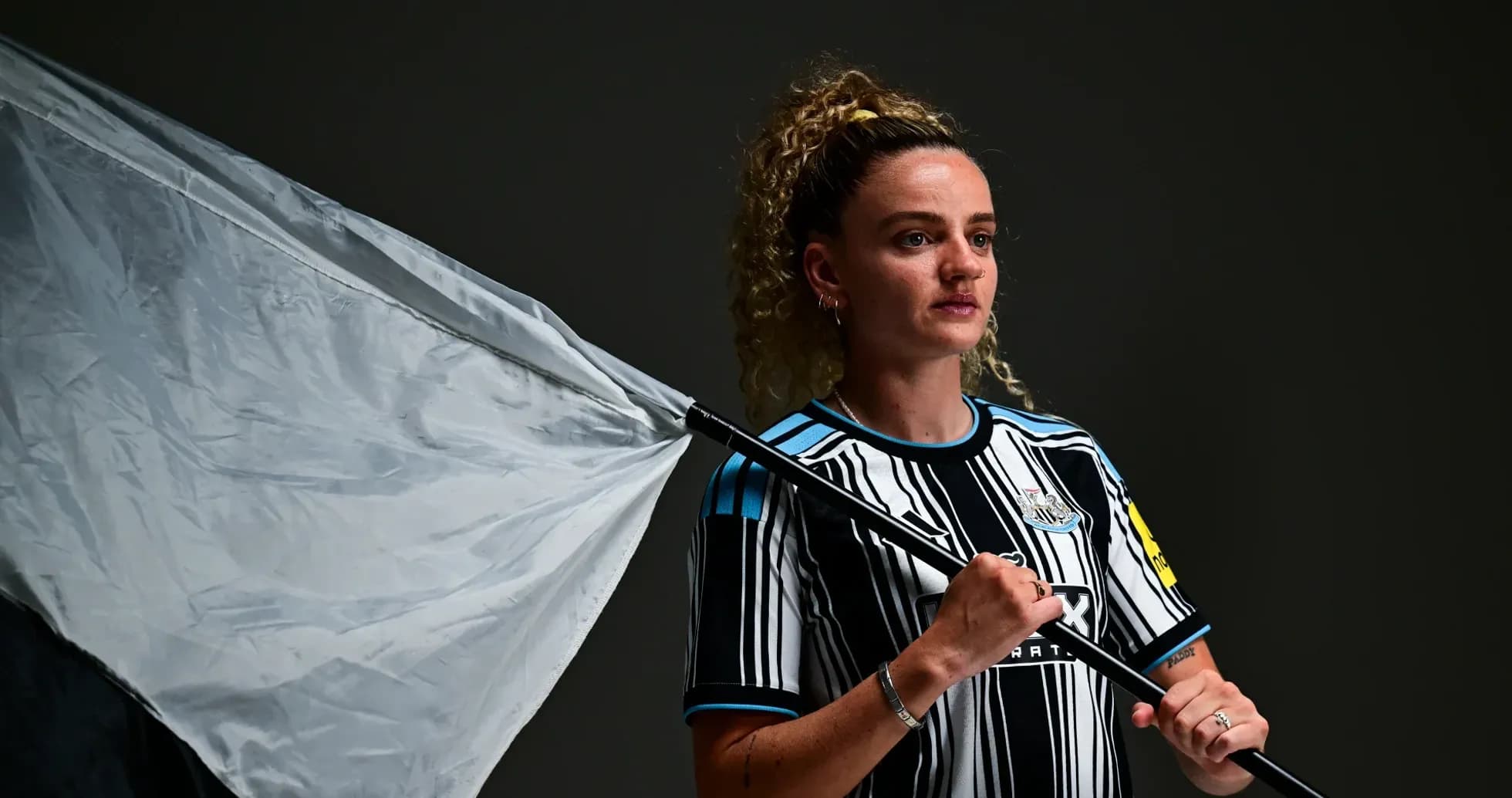 Jugadora sosteniendo una bandera de Newcastle United