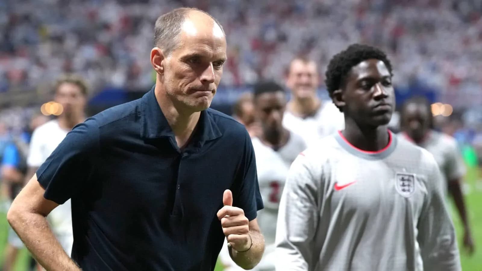 Entrenador y jugador saliendo del campo tras partido