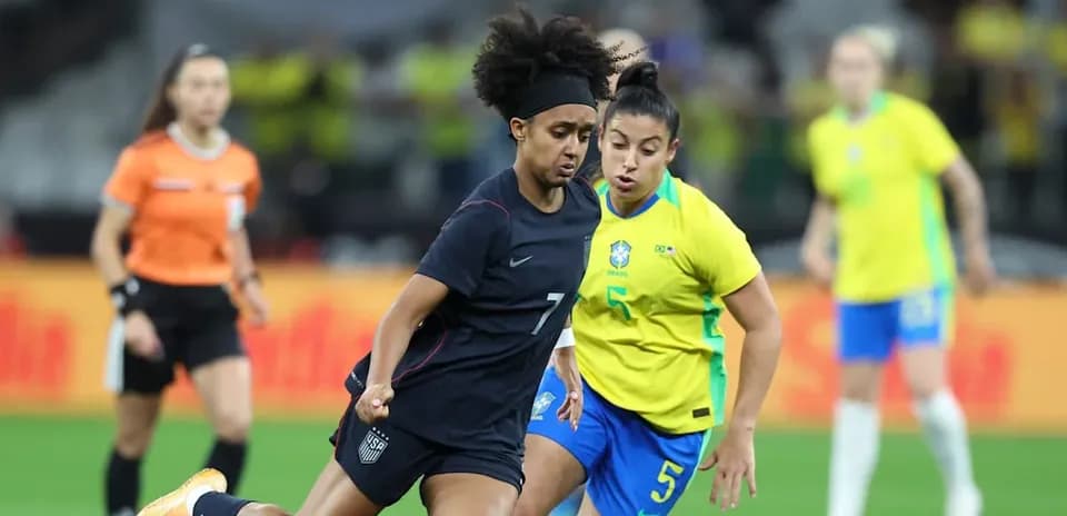 Jugadora de EE. UU. driblando ante jugadora de Brasil