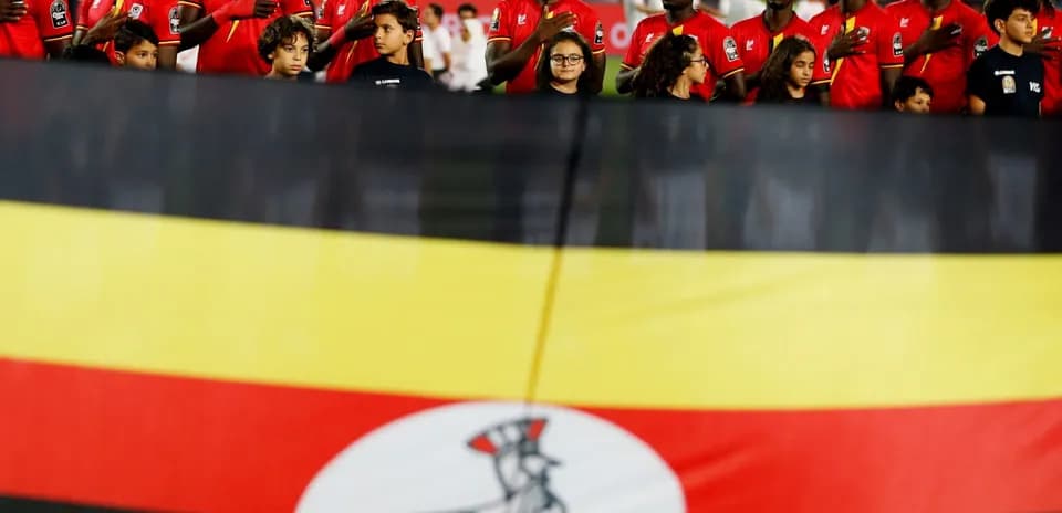 Jugadores de Uganda alineados con bandera nacional