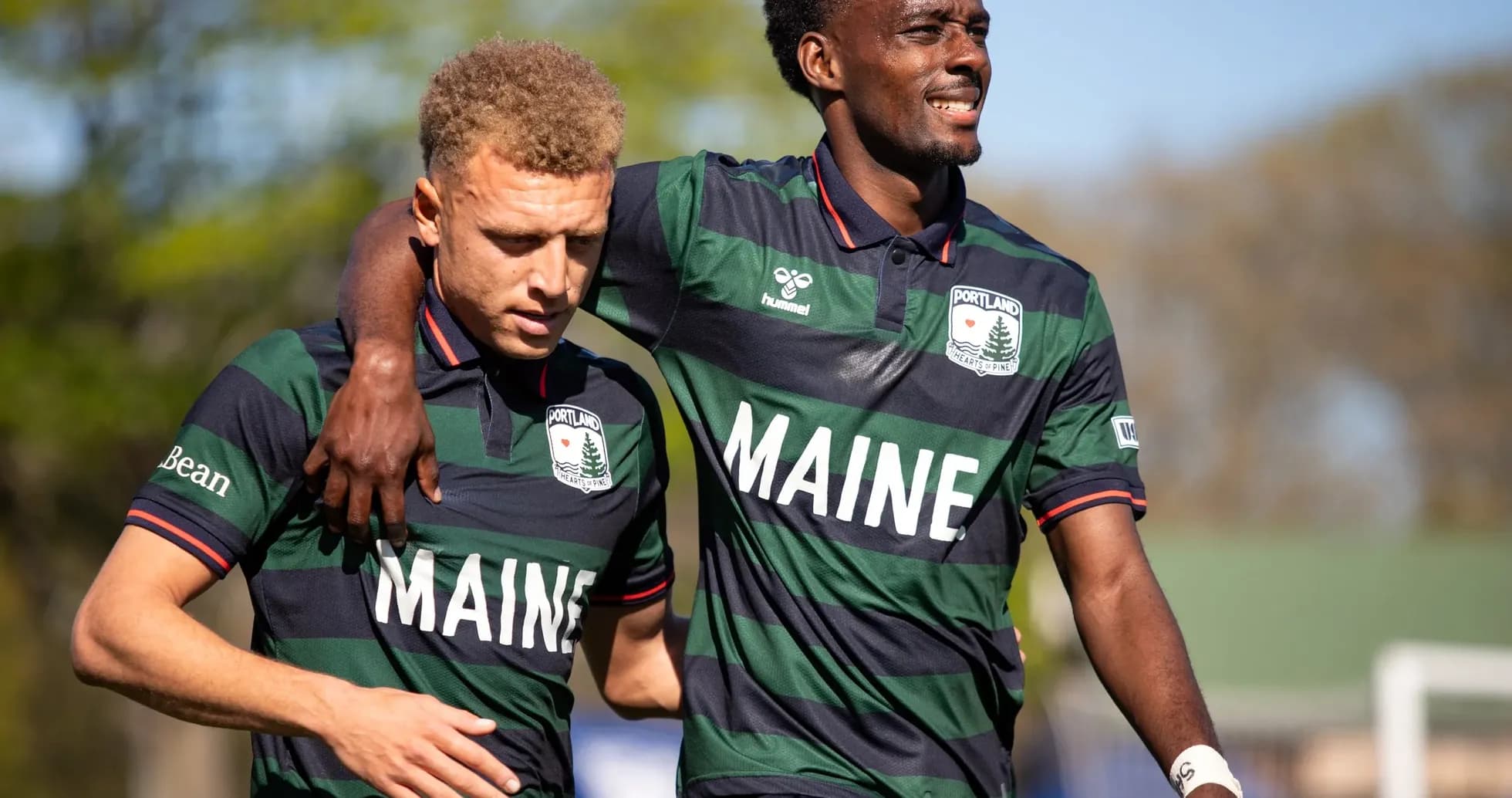 Dos jugadores del Portland Hearts of Pine abrazándose