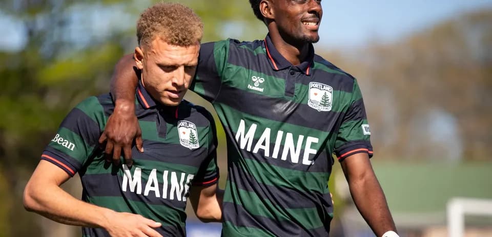 Dos jugadores del Portland Hearts of Pine abrazándose