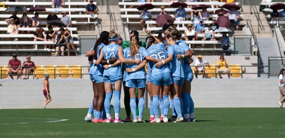 Jugadoras de fútbol en círculo antes del partido