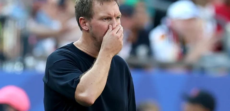 Entrenador pensativo en el área técnica del partido