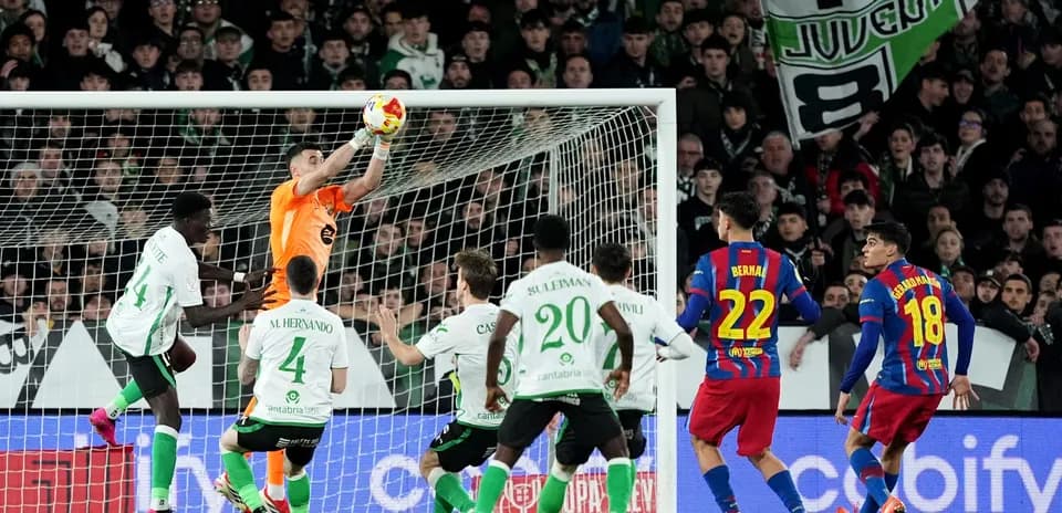 Portero deteniendo el balón en un partido de fútbol