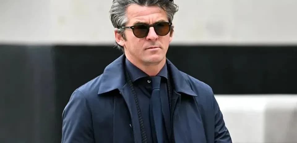 Hombre con gafas de sol y abrigo azul caminando