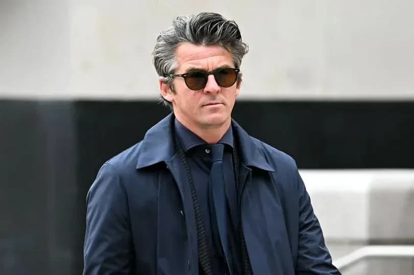 Hombre con gafas de sol y abrigo azul caminando