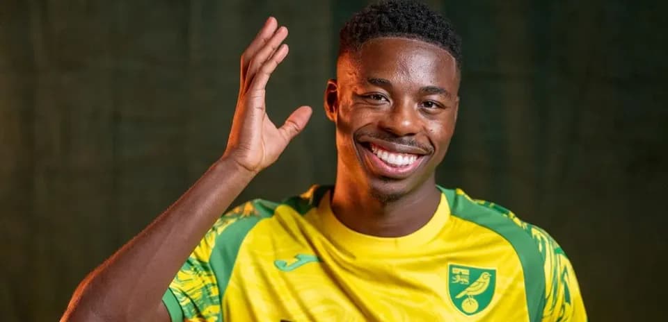 Jugador sonriendo y saludando con camiseta amarilla