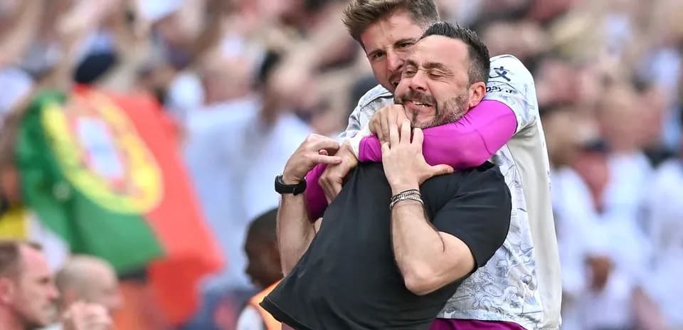 Dos entrenadores abrazándose en celebración durante el partido