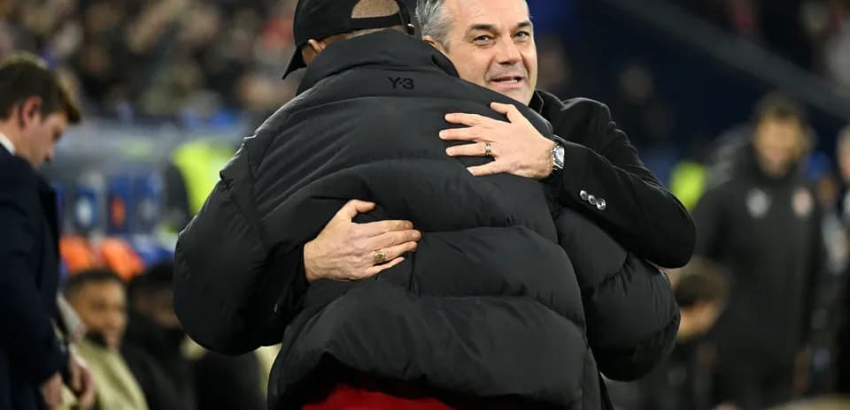 Dos entrenadores abrazándose en el banquillo