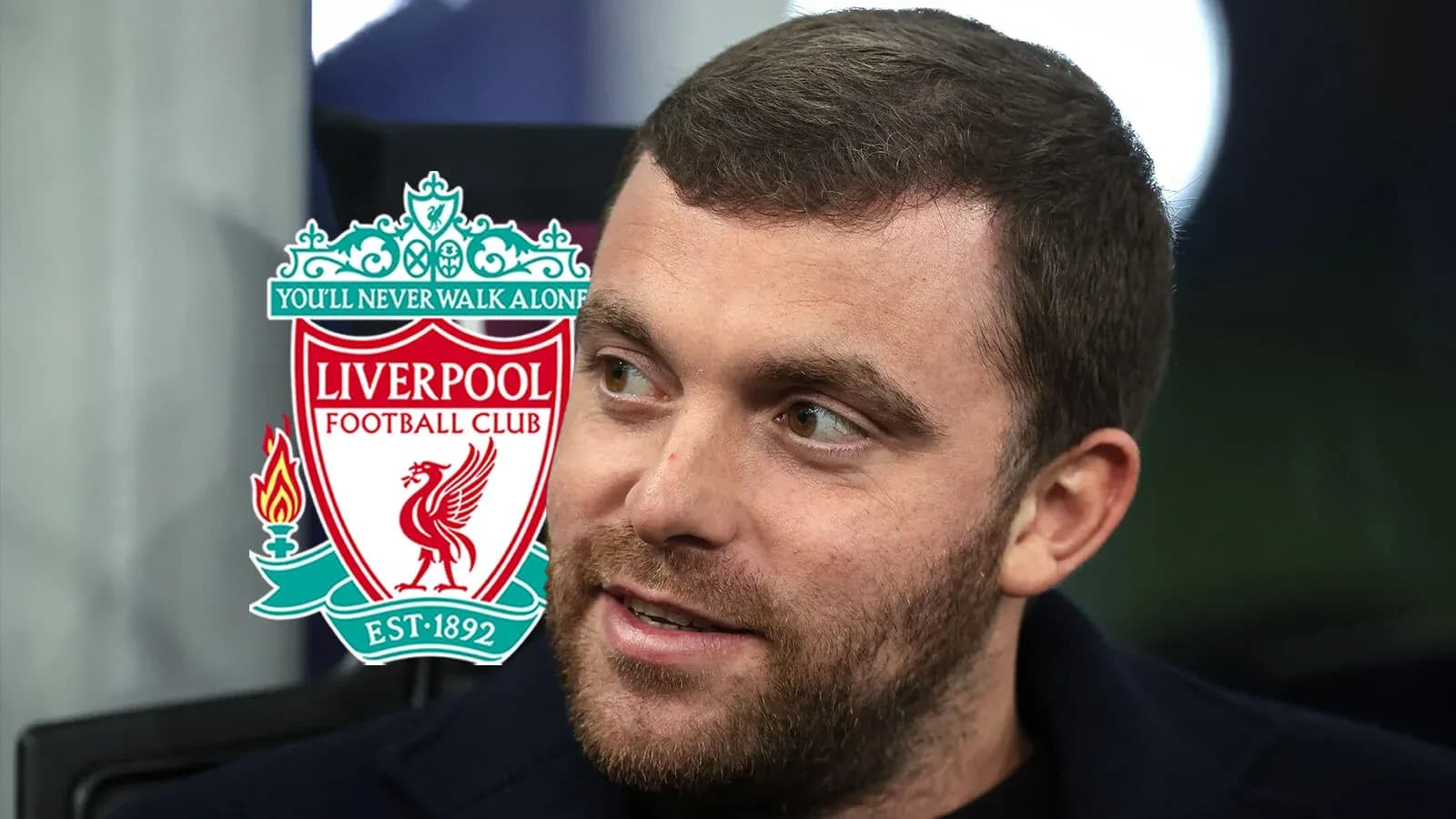 Hombre hablando con el logo del Liverpool de fondo