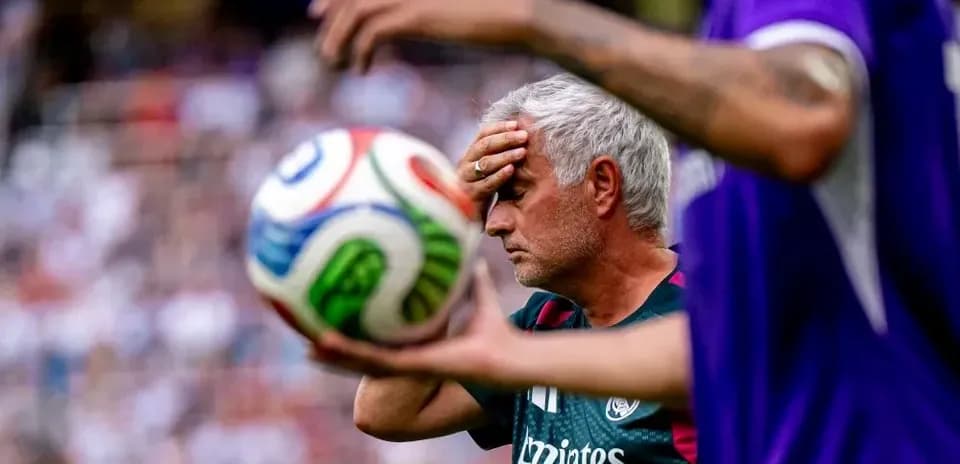 Entrenador sosteniendo la frente durante el partido