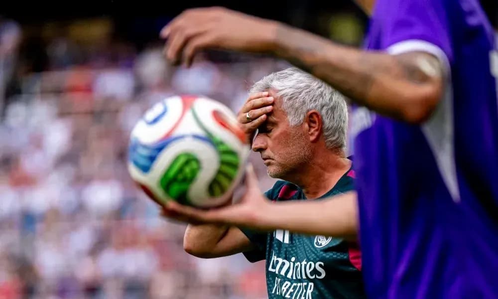 Entrenador sosteniendo la frente durante el partido