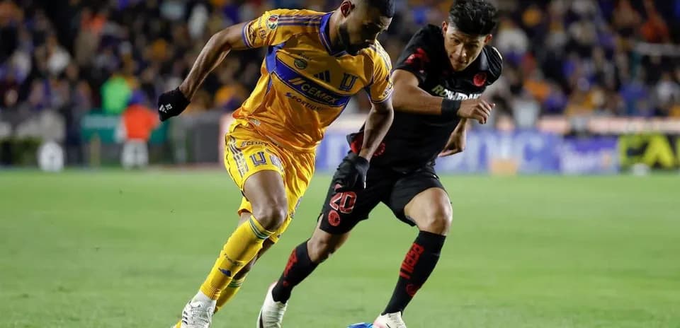 Jugadores de Toluca y Tigres compitiendo por el balón