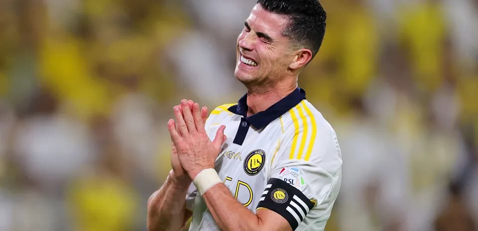 Jugador aplaudiendo durante partido con aficionados al fondo