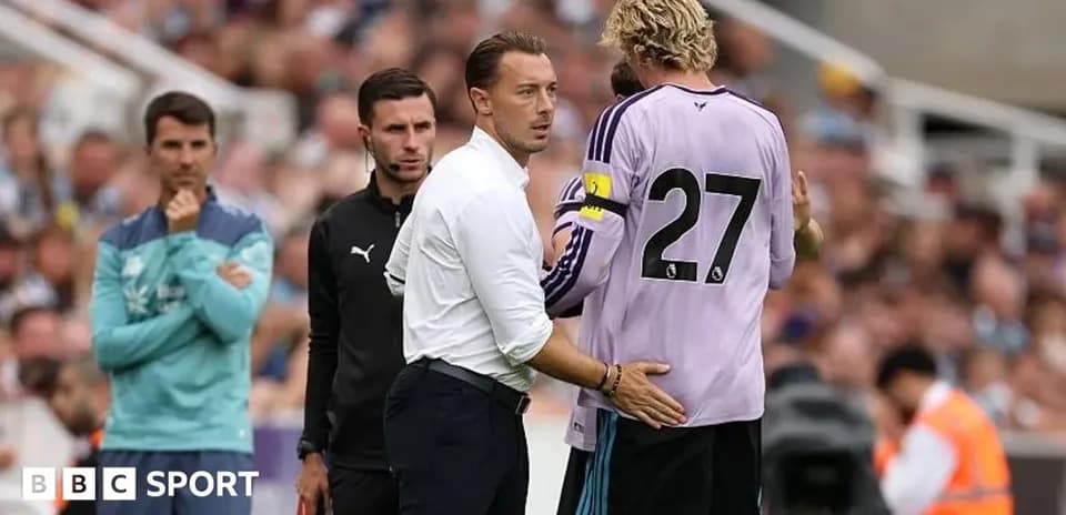 Entrenador hablando con portero durante partido