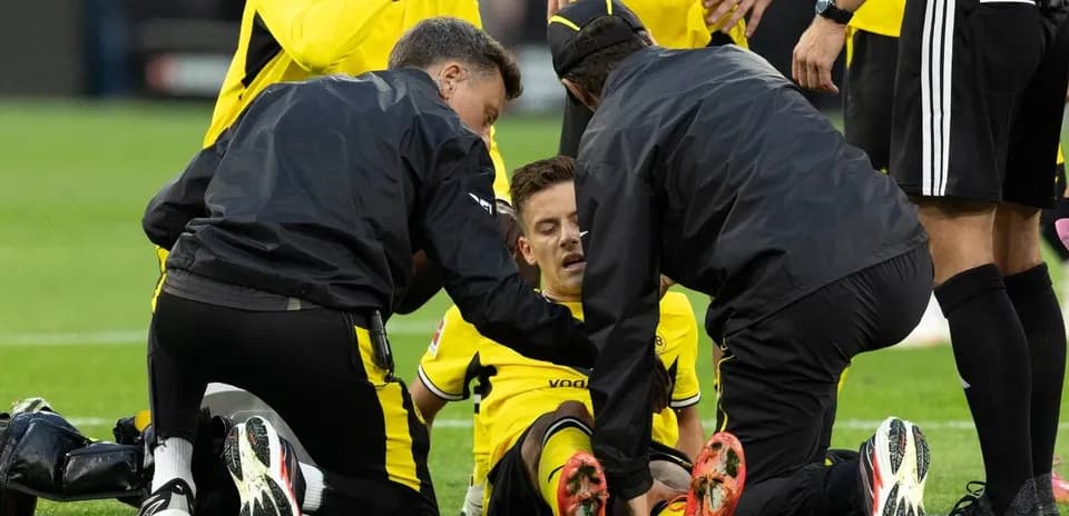 Jugadores y personal médico atendiendo a un jugador lesionado