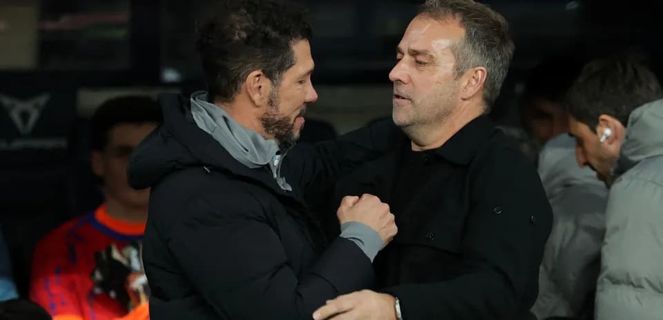 Entrenadores saludándose en el banquillo del estadio