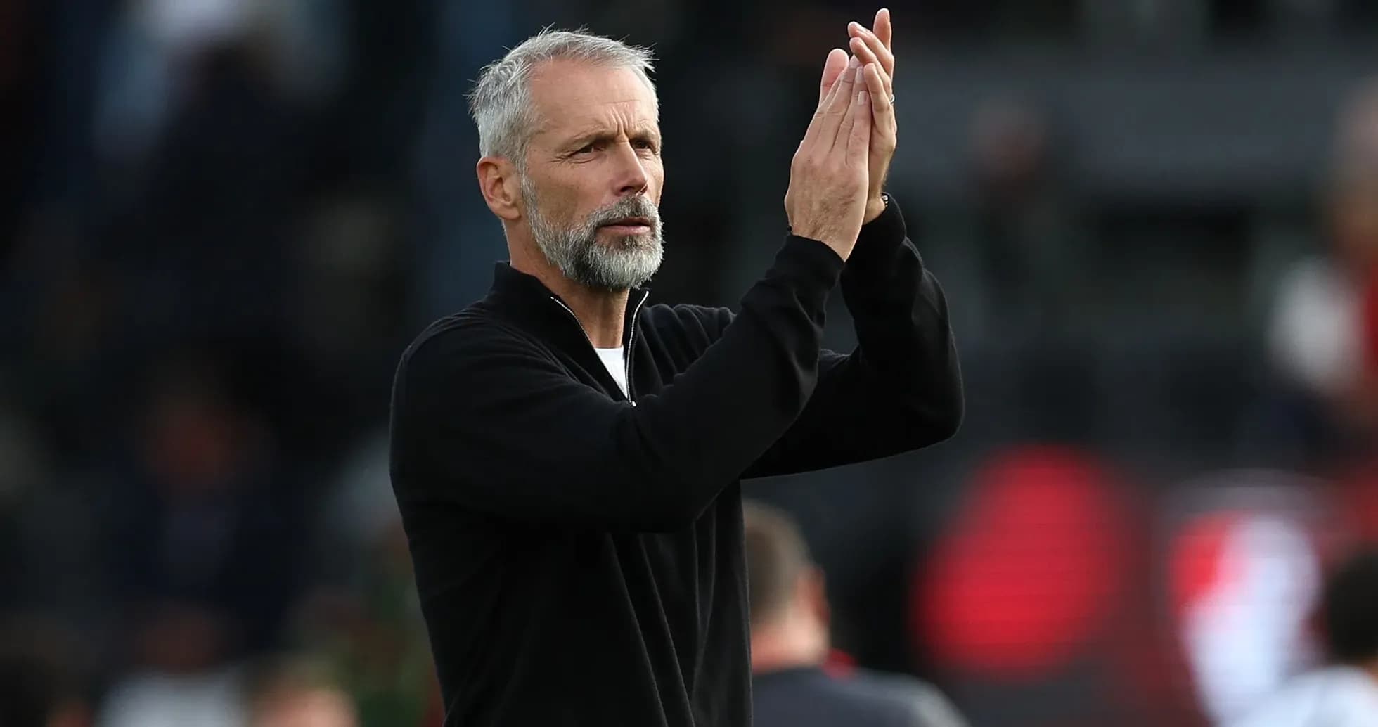 Entrenador aplaudiendo en el campo de juego