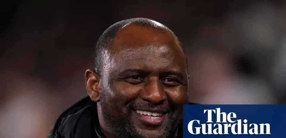 Entrenador sonriendo durante un partido de fútbol
