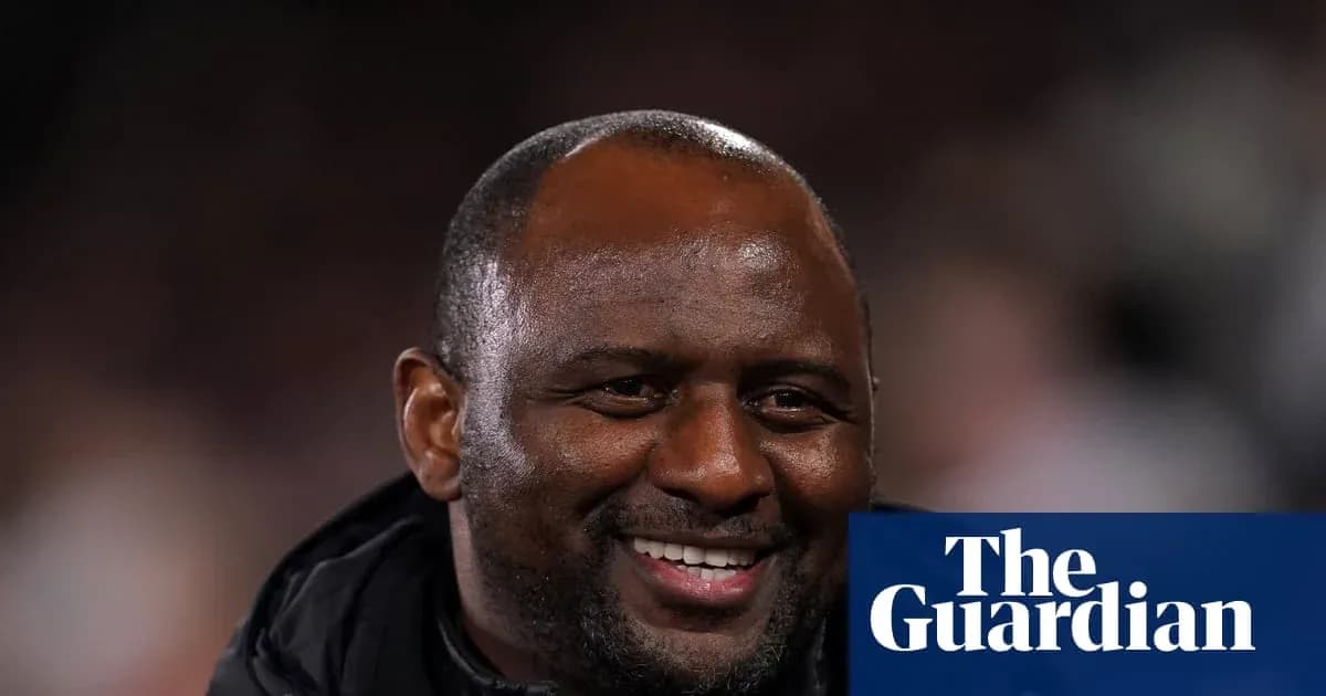 Entrenador sonriendo durante un partido de fútbol