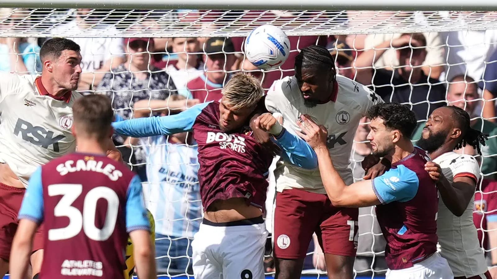 Jugadores disputando un balón en el área de gol