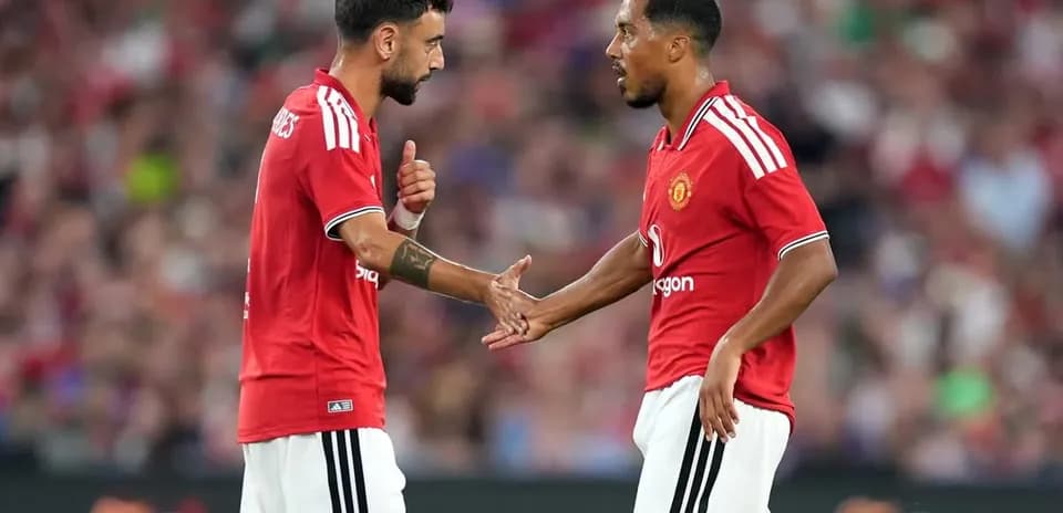 Jugadores de Manchester United intercambiando ideas en el campo