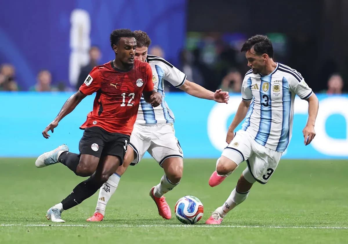 Jugador de Egipto driblando entre dos jugadores argentinos