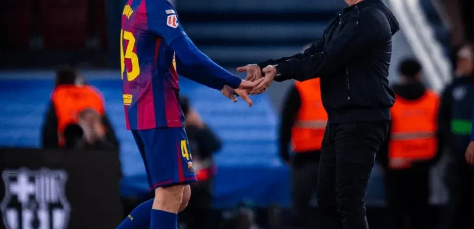 Jugador y entrenador intercambiando saludos en el campo