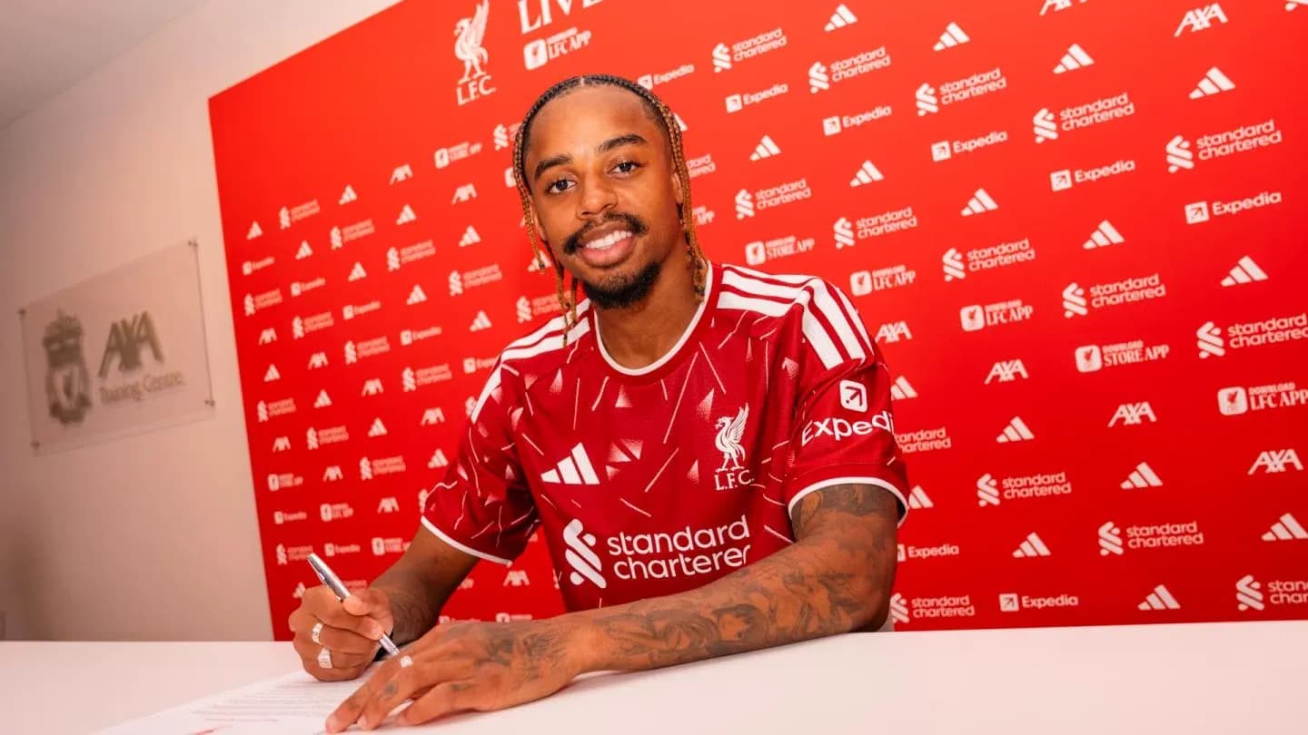 Jugador de Liverpool firmando contrato en mesa
